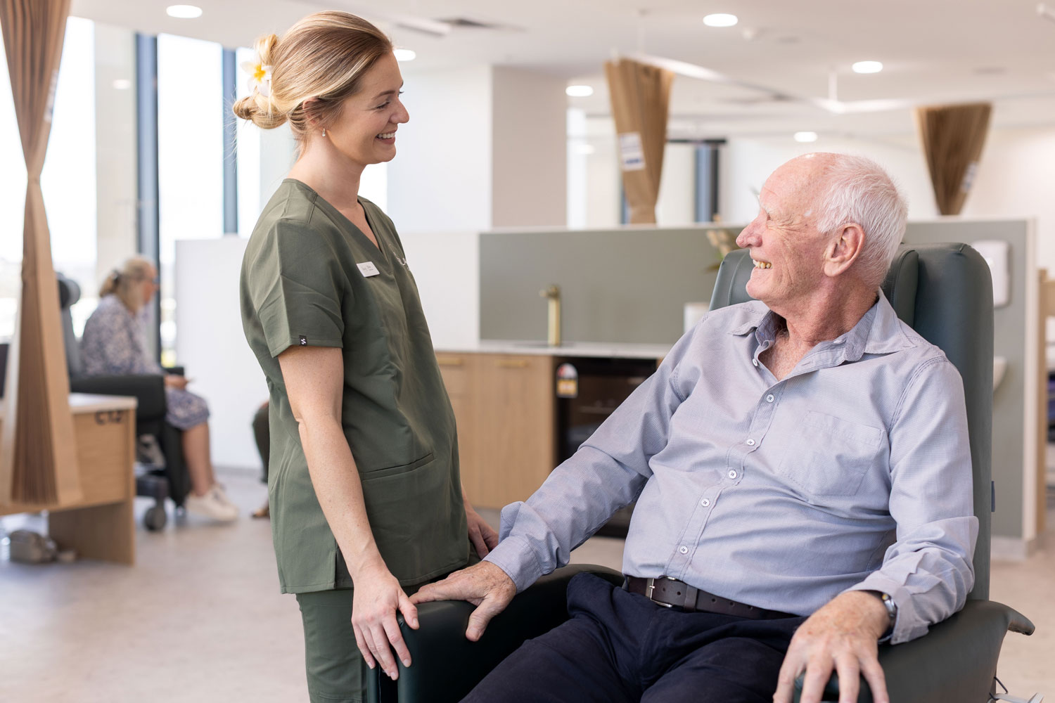 Nurse speaking with an older male patient in a treatment chair at The Solace Clinic in Maroochydore.